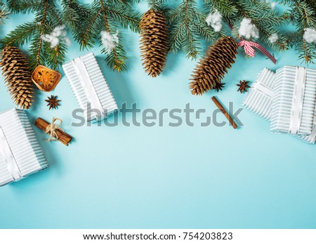 Christmas background - fir leaves and pine cones decorating elements on blue table. Creative Flat layout and top view composition with border and copy space design