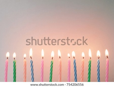 Colorful birthday candle sticks, alternating beautiful colors on the old plank background