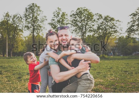 father with three children having fun in the park. hipster style. casual clothes. concept of happy family Royalty-Free Stock Photo #754220656