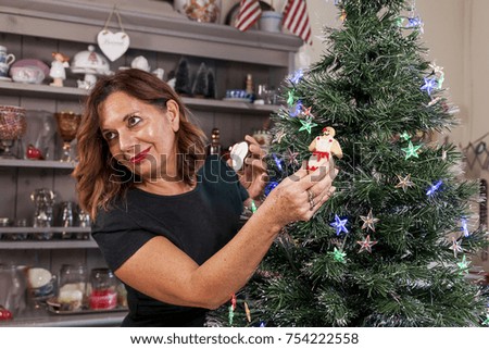 mother and son decorating the christmas tree with homemade biscuits