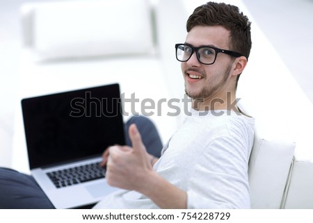 closeup. modern young sitting in front of the open laptop and showing thumb up. photo with copy space.