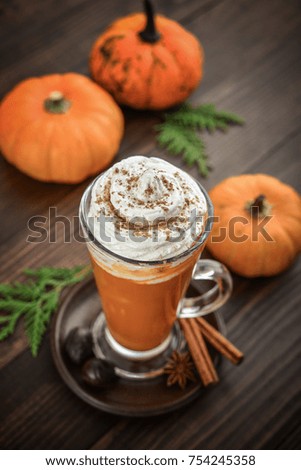 Pumpkin spice latte with whipped cream on wooden background