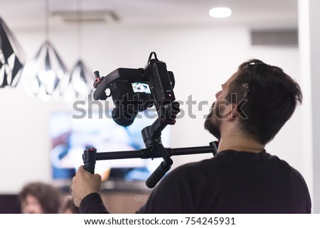 young videographer with gimball video slr at work