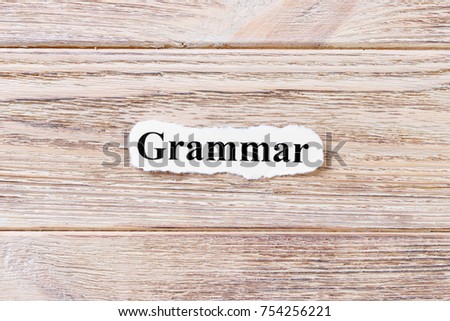 Grammarof the word on paper. concept. Words of Grammar on a wooden background.