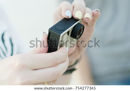 The woman is holding a new action camera