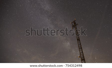 Communications tower in starry night with milky way