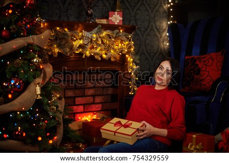 Pregnant girl waiting for a Christmas miracle at a smart Christmas tree with burning garlands