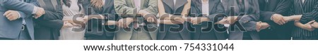 Smiling business team standing upright with holding hands. Mixed race business team concepts. Royalty-Free Stock Photo #754331044