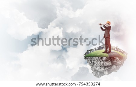 Engineer man standing on green floating island in blue sky