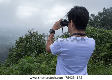 man are taking picture of nature and water fall
