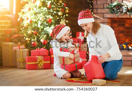 christmas morning. happy family mother and daughter unpack, open christmas gift 