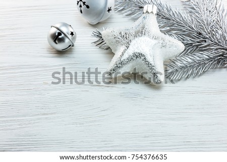 silver christmas tree decorations and fir tree branch on white wooden table background