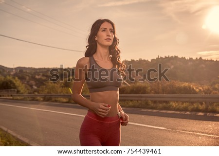 one young woman, outdoors jogging walking, sport clothes, Sun sky, warm summer, rural area, upper body shot Royalty-Free Stock Photo #754439461