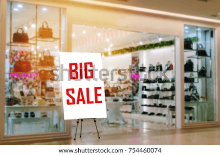 advertising billboard with BIG SALE word for discount in front of luxury fashion bag store in department store shopping mall, black friday sale, special offer, commercial, marketing and concept