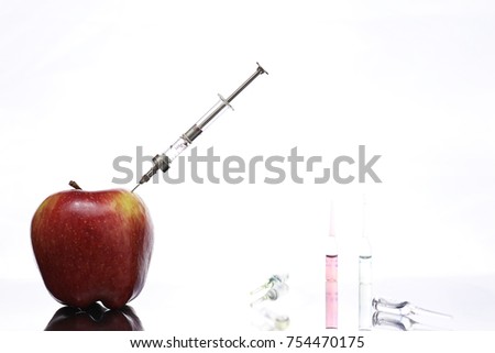 Genetically modified foods, apple pumped with chemicals from a syringe