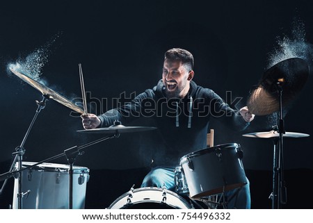 Drummer rehearsing on drums before rock concert. Man recording music on drum set in studio Royalty-Free Stock Photo #754496332