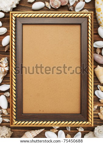 Photo gold frame and sea shells on wood background