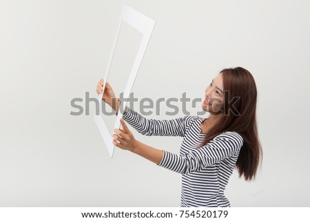 A young woman holding a frame