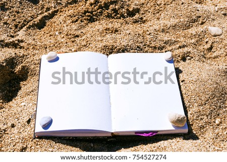 a notebook on the sand