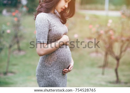 A asian pregnant is happy with her body, her foetus. Royalty-Free Stock Photo #754528765