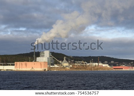 District heating plant with lot of smoke coming out of chimney, Picture from the Northern Sweden.