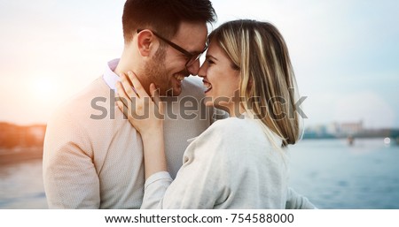Couple kissing dating on bridge during sunset Royalty-Free Stock Photo #754588000