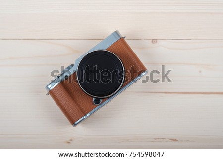 modern and stylish mirrorless camera brown color on a light wooden Board Royalty-Free Stock Photo #754598047