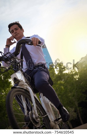 Young buinessman riding a bicycle to work in the city.