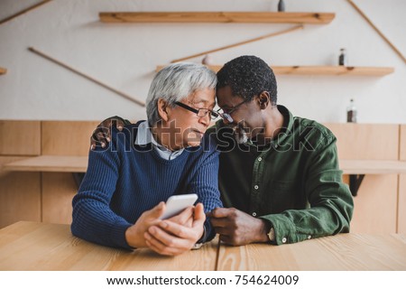 multiethnic senior men embracing while spending time together Royalty-Free Stock Photo #754624009