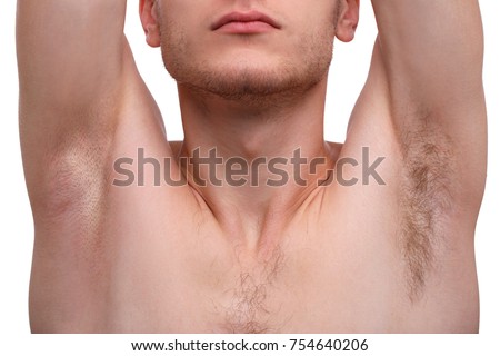 Close-up of a man raising his hands and showing his armpits, one armpit shaved, the second is not, isolated on white background.