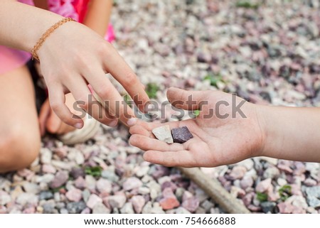 Little girl taking stones from friends hand. Concept of trust Royalty-Free Stock Photo #754666888