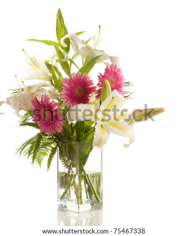 a bunch of lilies and gerberas in the transparent vase  isolated  on the white background
