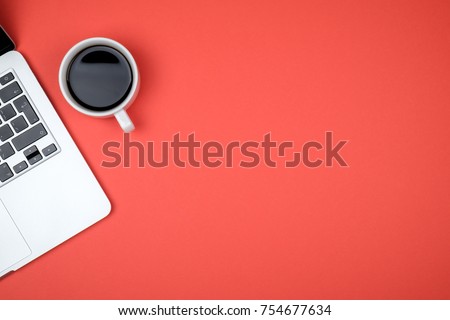 Top view of workspace with laptop, cup of coffee and copy space on colored background