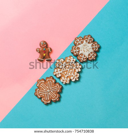cookies in the shape of snowflakes and gingerbread man on pink and blue background. the concept of new and Christmas. winter holiday treats