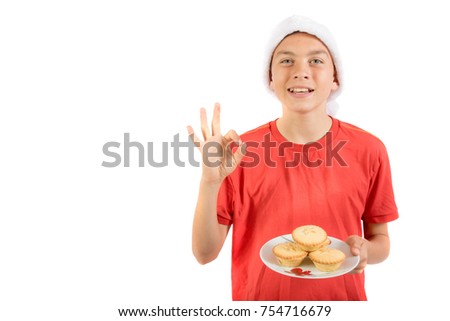 Teenage boy with a plate of mince pies giving positive gestures