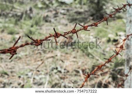 Rust barbed wire tension, close up shot