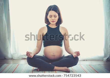 pregnancy, yoga, people and healthy lifestyle concept - happy pregnant woman meditating at home,Vintage style Royalty-Free Stock Photo #754723543