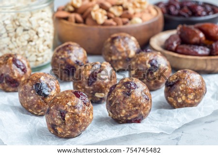 Healthy homemade energy balls with cranberries, nuts, dates and rolled oats on parchment, horizontal Royalty-Free Stock Photo #754745482