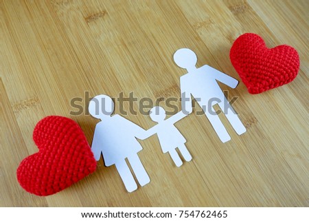 Paper silhouette of family with red heart on wooden - family concept