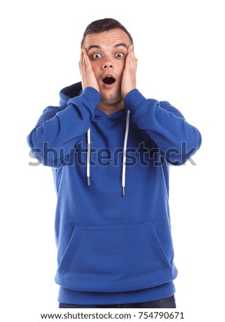 Portrait of a young guy in a blue sweatshirt, emotion of shock, isolated on white background