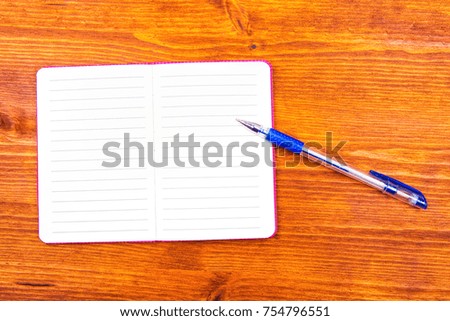 Notepad with pencil on wood board background