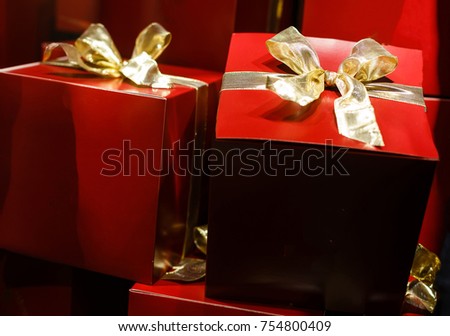 Christmas gifts presents on red background. Simple, classic, red gift boxes with ribbon bows and festive Christmas decorations
