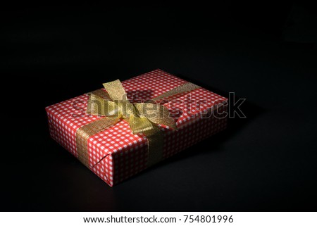 Red gift box in the dark, The present for Christmas, New year, Birthday or Valentine. the picture of the red gift box using low key technique.