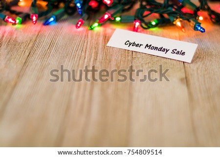 Cyber Monday Sale Concept on wooden board and colored lights, selective focus, room for copy