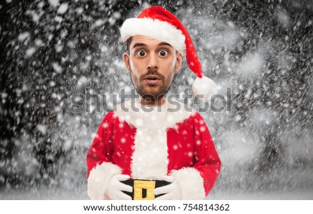 christmas, holidays and people concept - man in santa claus costume over snow background (funny cartoon style character with big head)