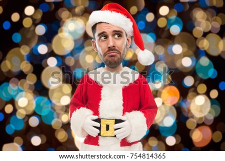 christmas, holidays and people concept - sad man in santa claus costume over lights background (funny cartoon style character with big head)