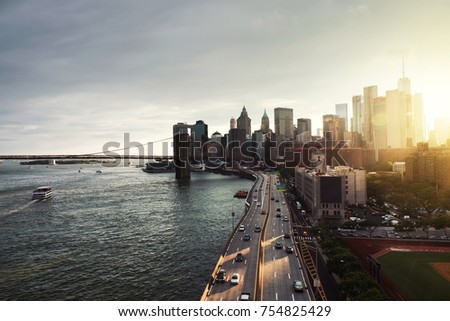 New York, USA. Aerial view on the city skyline in New York City, USA during the sunset. Famous skyscrapers of the concrete jungle and car traffic. Brooklyn bridge