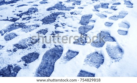 Dirty footprints in the snow in the winter. 