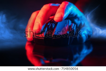 Close up of Hand over wireless Game Mouse on dark background and smoke ; The finger ready to click