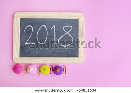 2018 on school Slate Blackboard with wooden frame with paperclips and coloful of eraser on pink background, Top view hand drawing new year 2018 with copy space